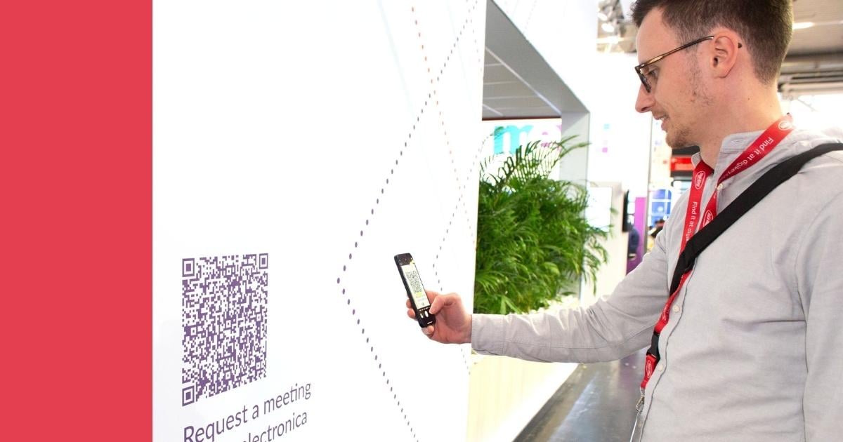 Image showcasing an event attendee scanning a QR code at the Velocity Electronics trade show booth. This interactive element, seamlessly incorporated into the booth design, provided an efficient and user-friendly method for booking appointments and accessing additional company information.